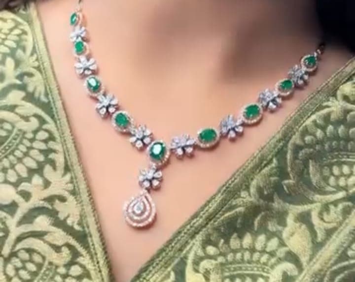 Chawla Jewellers Diya emerald floral necklace — oval emerald diamond halos with floral motifs and layered teardrop pendant